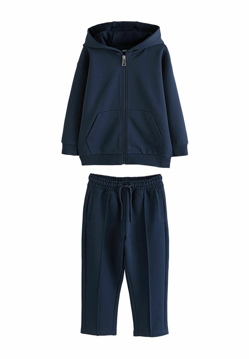 Navy blue zip-up hooded sweatshirt with two front pockets, paired with matching jogger pants featuring an elastic waistband and side pockets.