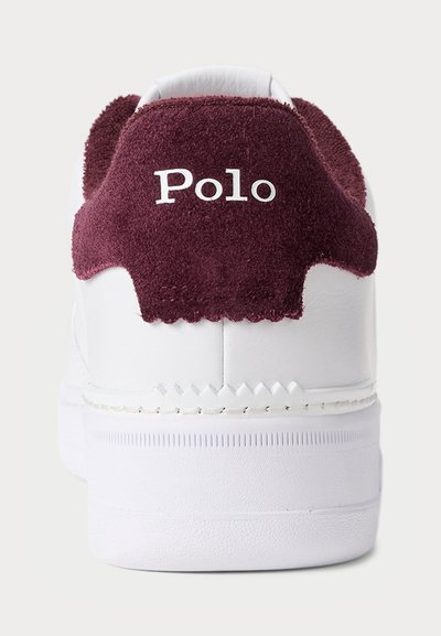 Baltie sporta apavi ar tumši sarkanu zamšas papēdi, kurā ir balts logos "Polo". Apava augšdaļa izgatavota no gludas sintētiskas vielas, un tam ir strukturēta zole.