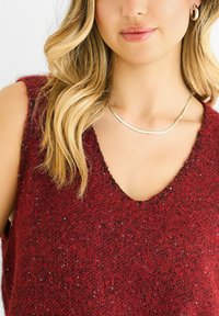 Burgundy knit sleeveless top with a deep V-neck, featuring a textured finish and scattered sequins for added detail. Clean neckline with no embellishments.