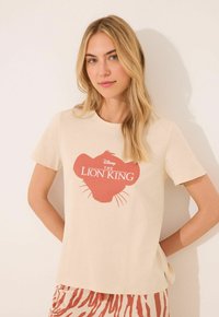 Beige bavlněné tričko s motivem siluety červeného lva a textem "Král lev". Krátké rukávy, kulatý výstřih, uvolněný střih.