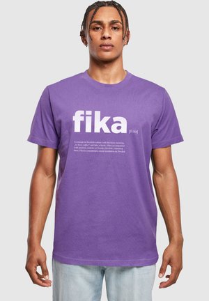 T-shirt en coton violet à manches courtes avec le mot "fika" en grandes lettres blanches et un texte descriptif en dessous. Coupe décontractée.