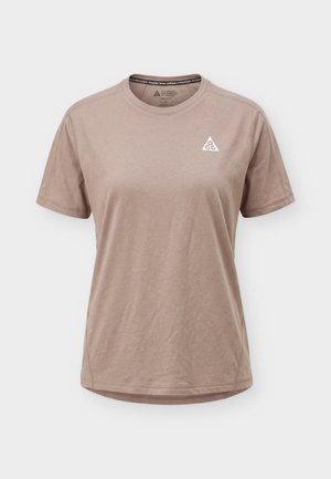 Béžové tričko s krátkym rukávom a okrúhlym výstrihom, s malým bielym logom ACG trojuholníka na ľavej strane hrude.