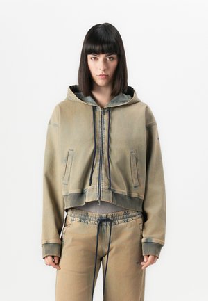 Kuttet, beige hettegenser med glidelås og snor, har frontlommer og ribbestrikket kant. Kombinert med matchende beige joggebukser med snor.
