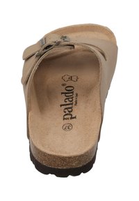 Sandalia deslizante beige con una correa de hebilla, plantilla de corcho, parte superior de cuero suave y suela texturizada. Logo grabado en el interior de la sandalia.