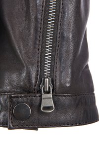 Braune Lederjacke mit einem silbernen Reißverschluss, strukturiertem Finish und metallenen Druckknöpfen an den Bündchen, die das handwerkliche Können betonen.