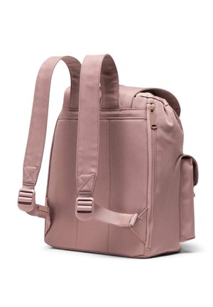 Sac à dos en tissu rose avec des bretelles réglables, un dessus zippé, une poche latérale et une forme rectangulaire structurée. Finition en matériau texturé.