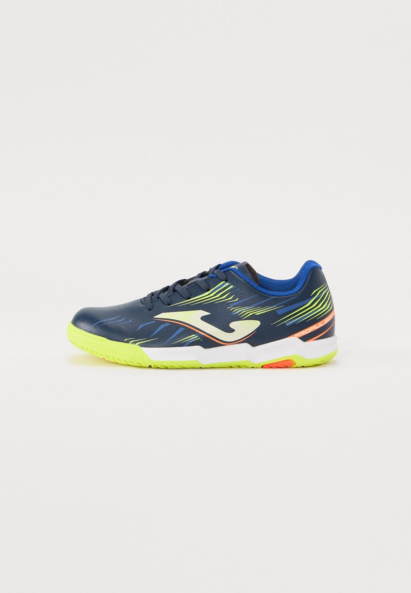 Scarpe sportive con una tomaia blu navy e accenti verdi e gialli, in materiale tessile, suola bianca e un logo distintivo sul lato.