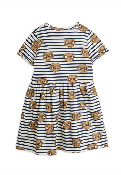 Dryžuota suknelė su raukinėta sijonu, puošta rudos spalvos svetimkūnių galvų raštu. Minkšta medžiaga, apvalus iškirpimas ir trumpomis rankovėmis. Mėlynos ir baltos spalvų dryžiai.