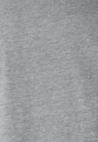 Gros plan sur un tissu gris avec de fines rayures diagonales noires créant un motif texturé subtil sur toute la surface.