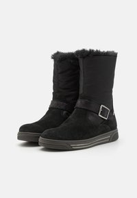 Bottines noires en suède et nylon, avec un haut doublé en fourrure, une sangle avec boucle en argent et une semelle en caoutchouc texturé.