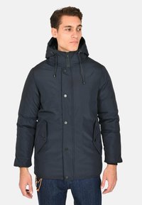 Giacca puffer blu navy con cappuccio, dotata di chiusura lampo frontale, bottoni a pressione e due tasche laterali. Realizzata in materiale liscio e resistente all'acqua.