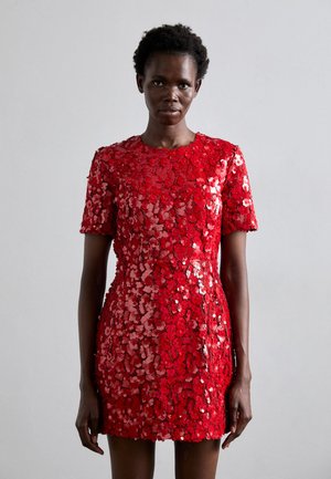 Vestido rojo de lentejuelas con mangas cortas, escote redondo, silueta ajustada y una textura brillante en toda su superficie. Variaciones sutiles en el tono aportan profundidad.