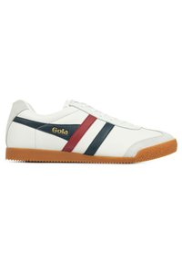 Vit sneaker med marinblå och röda horisontella ränder, texturerad gummisula och guld "Gola"-logotyp. Slät lädermaterial och klassisk design.