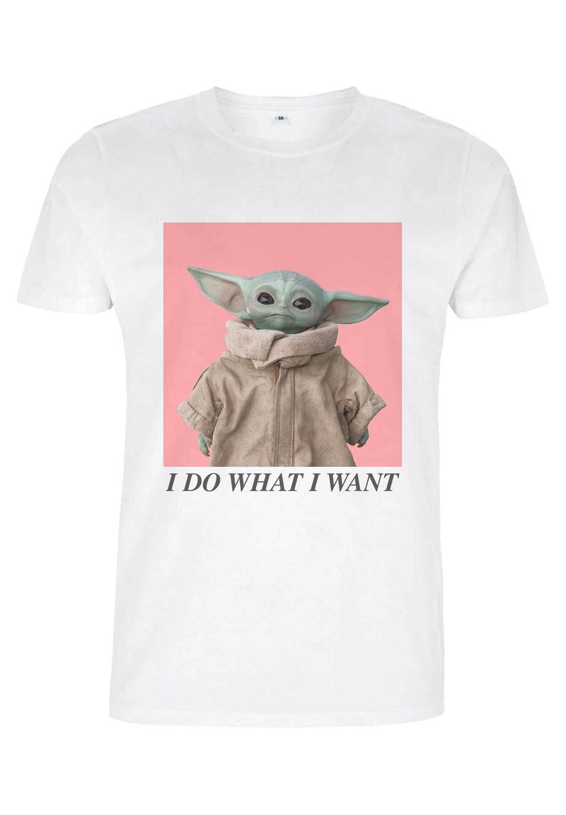 Biała koszulka z grafiką postaci w beżowej kurtce z wysokim kołnierzem, na różowym tle, z tekstem poniżej.