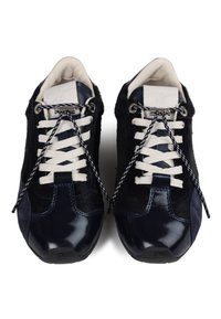 Dark navy sneakers with a mix of textured fabric and glossy material. Features include flat white laces and patterned black and white accents.