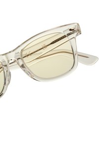 Prozirne plastične sunčane naočale s lagano žutim toniranim lećama, zakrivljenog dizajna, i metalnim akcentima na drškama. Bez brenda, s vidljivim oznakama.