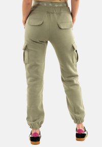 Joggers cargo en verde oliva, con una cintura acanalada, dos bolsillos traseros y puños elásticos en los tobillos para un look ajustado.