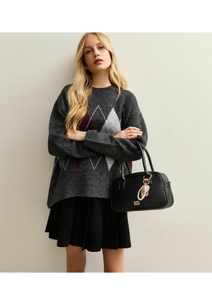 Maglione grigio a maglia con motivo a diamante in bordeaux e grigio chiaro, abbinato a una gonna nera plissettata e a una borsa nera con un charm.