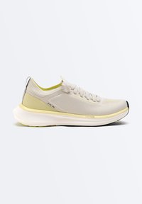 Chaussure de course beige clair et jaune avec tige en tissu tricoté, fermeture à lacets, semelle intermédiaire amortissante et détails noirs sur la semelle extérieure vue de côté.