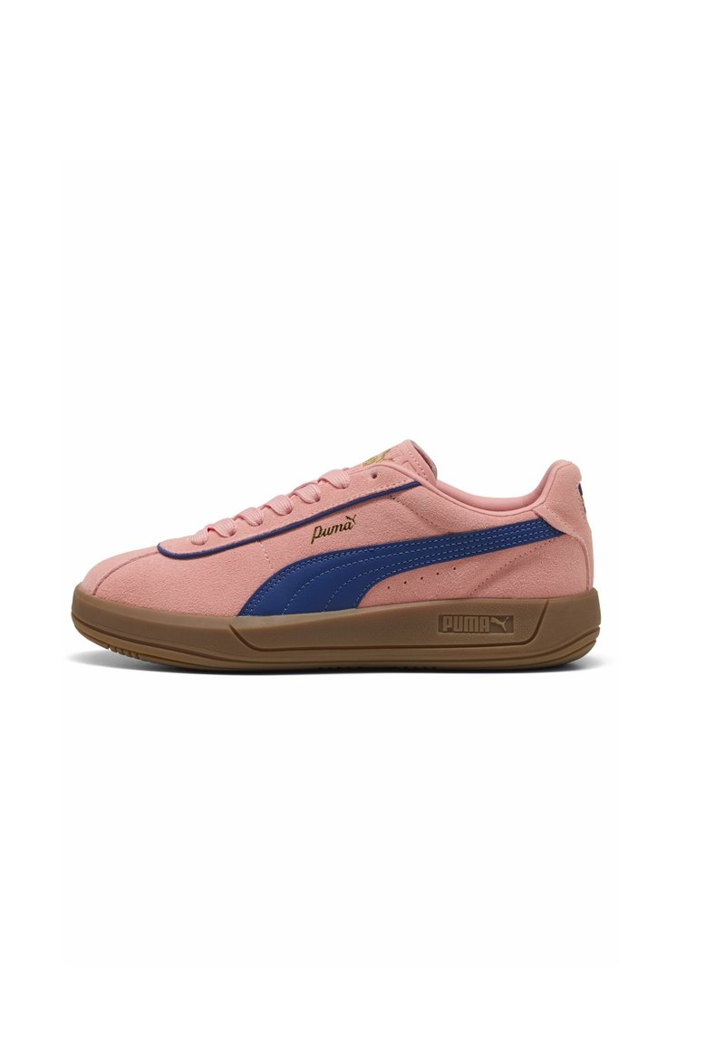 Puma-sneakers i rosa mocka med en blå rand, utrustade med en brun gummisula, rundad tå och platta skosnören. Guldfärgat logodetalj på sidan.