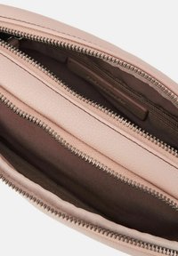 Pochette in pelle rosa chiaro con due scomparti con zip. L'interno presenta una fodera marrone liscia e hardware della zip in tonalità argento.