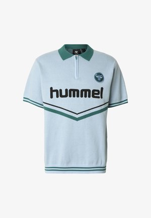 Világoskék galléros póló zöld gallérral, fekete "hummel" logóval és sötétebb zöld-fehér cikk-cakk mintával, rövid ujjú, bordázott szegéllyel.