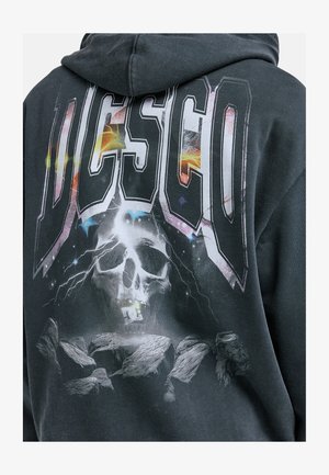 Czarna bluza z kapturem z dużą kolorową grafiką czaszki z piorunem, dużym napisem „DC” oraz formacjami skalnymi. Miękka tkanina z mieszanki bawełny.