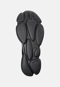 Black rubber shoe sole with textured grip, featuring a unique pod-like design and circular patterns, providing traction and flexibility.