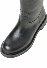Svart läderstövel med texturerad yta, rund tå och låg blockklack. Har en sydd söm längs kanten och en elegant silhuett.