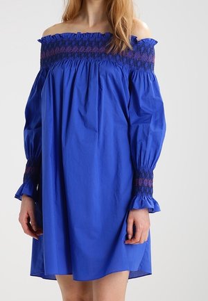 Sukienka w kolorze królewskiego błękitu z odkrytymi ramionami, marszczonym dekoltem i mankietami, długimi bufkami i luźnym fasonem sięgającym powyżej kolan.