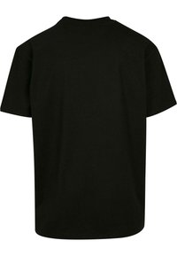 Camiseta de algodón negra con escote redondo, mangas cortas y un corte relajado. La parte trasera es lisa, sin ningún logotipo o patrón visible.