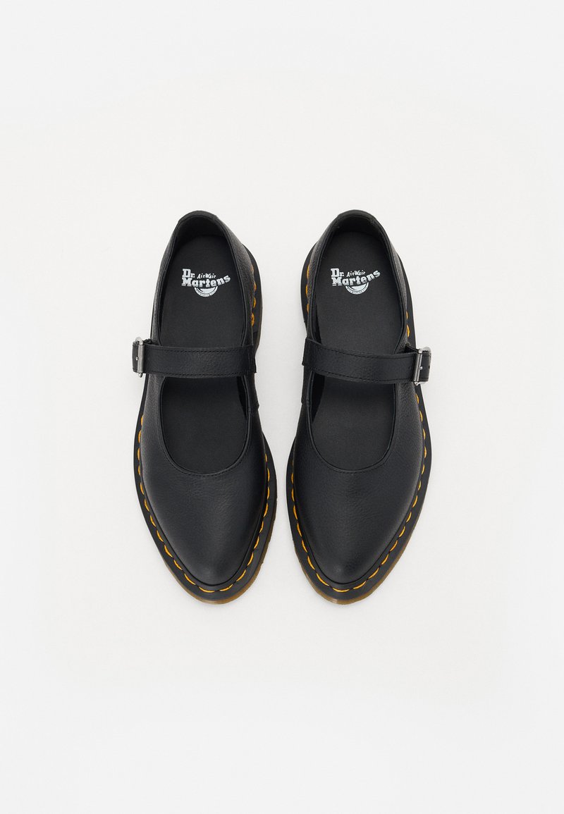 Black Mary Jane shoes with a curved toe, leather upper, adjustable strap, and yellow stitching on a thick rubber sole.
