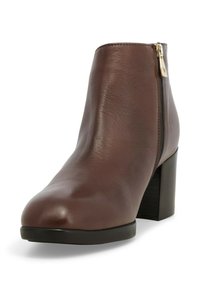 Stivale alla caviglia in pelle marrone con punta rotonda, cerniera laterale e tacco alto nero chunky. Texture liscia con un leggero brillante.