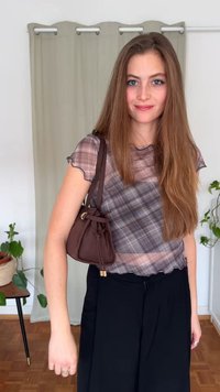 Ruudullinen, läpikuultava paita aaltoilevilla hihoilla, yhdistettynä löysiin mustiin housuihin ja pieneen ruskeaan säilytyspussiin, jossa on kiristysnauha ja kullanväriset yksityiskohdat.