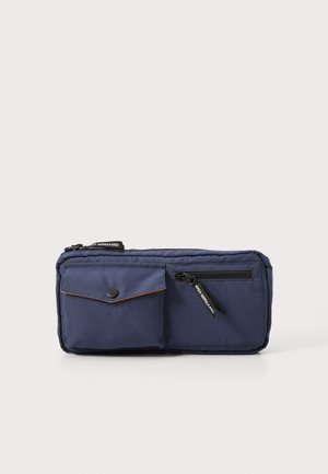 Borsetta rettangolare blu navy con una tasca a bottone a pressione e una tasca con cerniera, dotata di tirelli delle cerniere neri con testo del marchio.