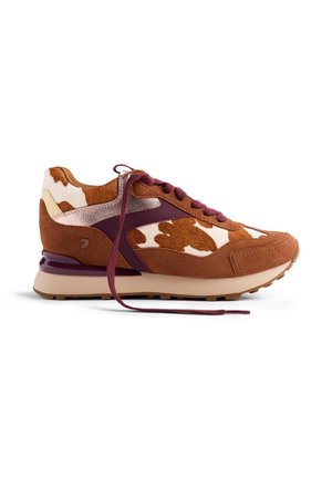 Baskets en imprimé vache brun et blanc avec des panneaux en daim et cuir, accents bordeaux et lacets bordeaux, présentées de côté sur un fond blanc.