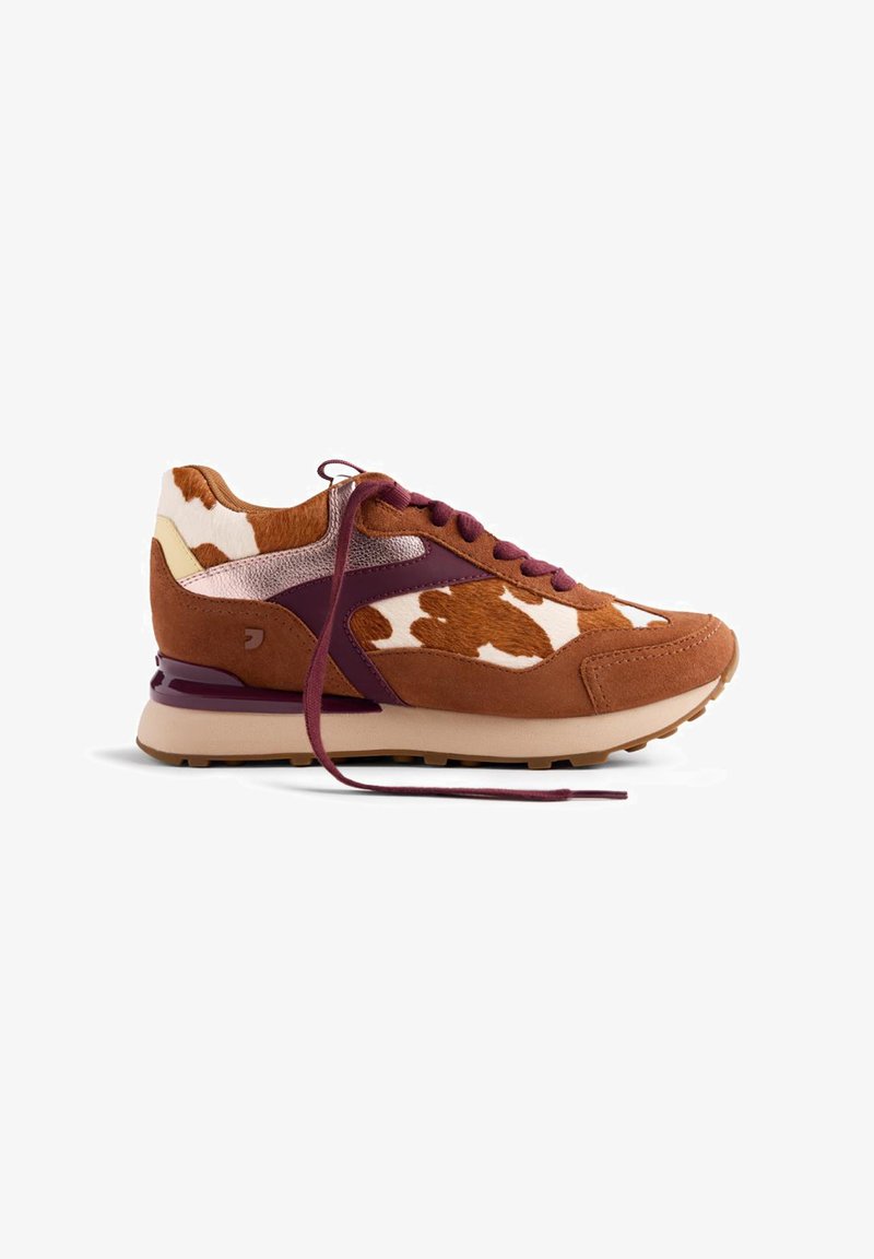 Baskets en imprimé vache brun et blanc avec des panneaux en daim et cuir, accents bordeaux et lacets bordeaux, présentées de côté sur un fond blanc.