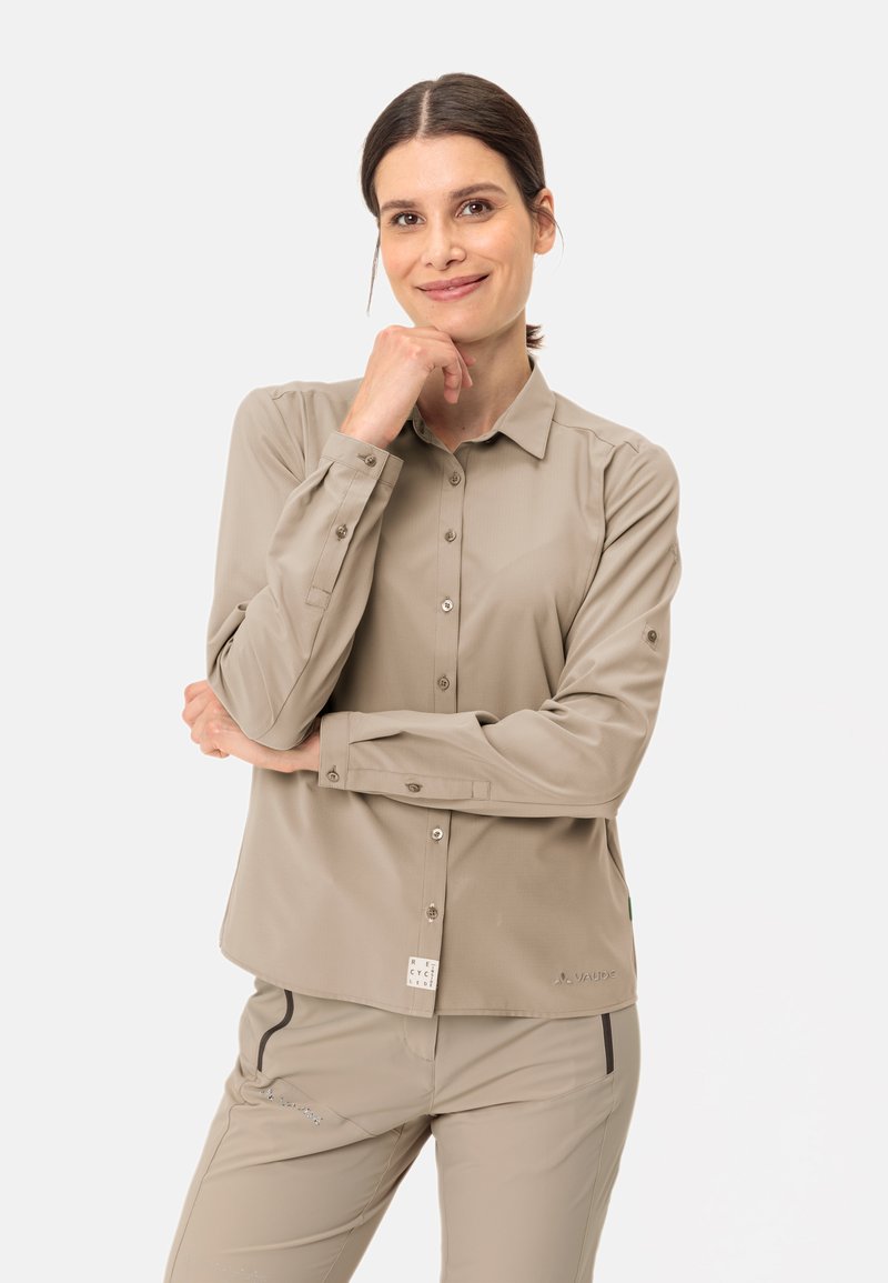 Camicia a maniche lunghe beige chiaro con chiusura a bottoni, colletto e polsini; presenta una texture liscia e un'etichetta del marchio discreta all'orlo.