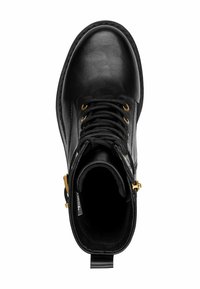 Bottines noires en cuir avec garnitures en or, un bout rond et des lacets noirs. L'intérieur est doublé et comprend une languette à l'arrière.