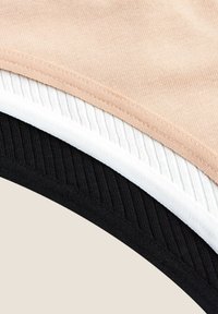 Trzy warstwy tkaniny: gładki bawełniany materiał w kolorze brzoskwiniowym, biały prążkowany bawełniany materiał i czarny prążkowany bawełniany materiał, ułożone w stos i częściowo nachodzące na krawędziach.