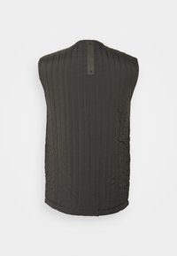 Bezrękawnik pikowany w ciemnoszarym kolorze, z pionowymi przeszyciami, wysokim kołnierzem oraz metką na środku pleców. Miękka, gładka tekstura.