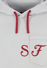 Jasnoszara hoodie z czerwonymi sznurkami, kieszenią na froncie oraz wyszywanym napisem "SF" w czerwonym kursywie na kieszeni. Gładka faktura, casualowy design.