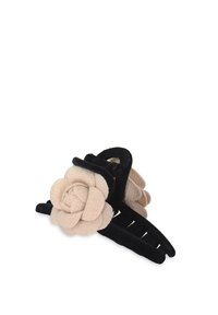 Svart hårklämma med en beige filtblomma, med en texturerad yta och flera taggar för bättre grepp.
