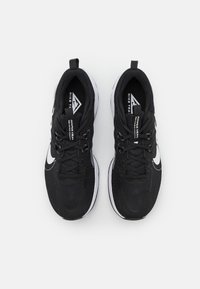 Zapatillas deportivas negras con parte superior de malla, cierre de cordones, cuello acolchado, logo de swoosh blanco y suela de goma blanca.