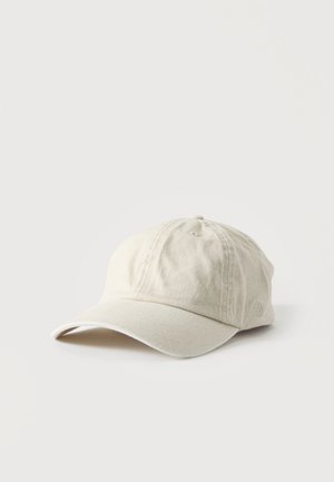 Casquette de baseball en coton beige avec une visière incurvée et des panneaux cousus, reposant sur une surface blanche simple.