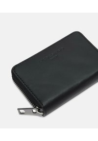 Czarny skórzany portfel z fakturowaną powierzchnią, zamkiem błyskawicznym i srebrnym okuciem. Na przedniej stronie znajduje się wytłoczony logo. Prostokątny kształt.