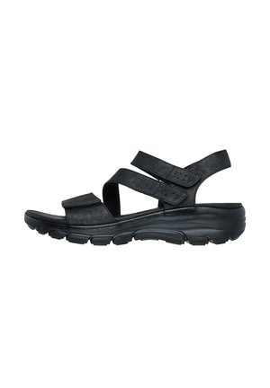 Sandalo nero con cinturini regolabili in Velcro, suola imbottita e materiale testurizzato. Il design privilegia il comfort e il supporto.