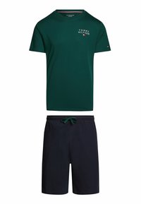 T-shirt in cotone verde con logo "Tommy Hilfiger", abbinato a pantaloni corti blu navy con vita elastica e cordino.