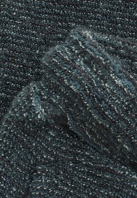 Dunkelblaues und graues strukturiertes Strickgewebe mit einem gerippten Bündchendetail, das weiche, geschlungene Garnfasern und ein gemütliches Muster zeigt.