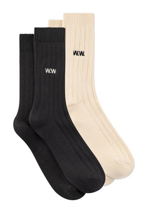 Dve pari rebrastih nogavic do sredine meče, en par črnih z belim logotipom "W.W.", en par bež s črnim logotipom "W.W.", prikazani položeni in ena čez drugo.